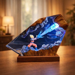 May include: A resin sculpture featuring a character in an orange and blue outfit, with spiky yellow hair, emitting a blue energy blast. The sculpture is encased in a clear resin with a wooden border and sits on a wooden base. The background is dark.