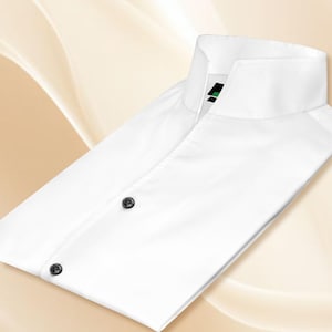 May include: A crisp white long-sleeved shirt featuring a high standing collar and a front placket with two visible black buttons. The interior collar label displays a small black and green graphic logo. The shirt is folded neatly.