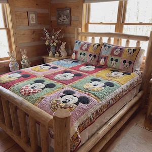 May include: A wooden bed frame with a colourful quilt featuring Mickey Mouse faces in various squares. The quilt has a patchwork design with red, blue, green, and yellow squares. Two matching pillows are on the bed.