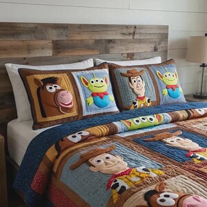 Puede incluir: Un juego de cama con un edred&oacute;n y dos almohadas con personajes de la pel&iacute;cula de animaci&oacute;n Toy Story. El edred&oacute;n y las almohadas tienen un dise&ntilde;o de patchwork con im&aacute;genes de Woody, Buzz Lightyear y otros personajes. La paleta de colores incluye marr&oacute;n, azul y beige.