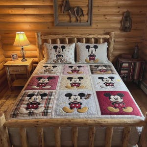 Op de afbeelding: Een Mickey Mouse-thema quilt- en kussenset op een houten bedframe. De quilt heeft een patchwork-ontwerp met verschillende vierkanten met Mickey Mouse in verschillende poses. De kussens hebben ook Mickey Mouse. Het bed staat in een rustieke, houten kamer.