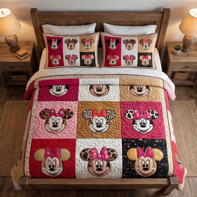 Peut inclure: Ensemble de courtepointe sur le th&egrave;me de Minnie Mouse avec des taies d'oreiller assorties. La courtepointe pr&eacute;sente un motif patchwork avec des visages de Minnie Mouse dans diff&eacute;rentes couleurs et motifs, dont le rouge, le rose et l'imprim&eacute; l&eacute;opard. La literie est pr&eacute;sent&eacute;e sur un cadre de lit en bois.