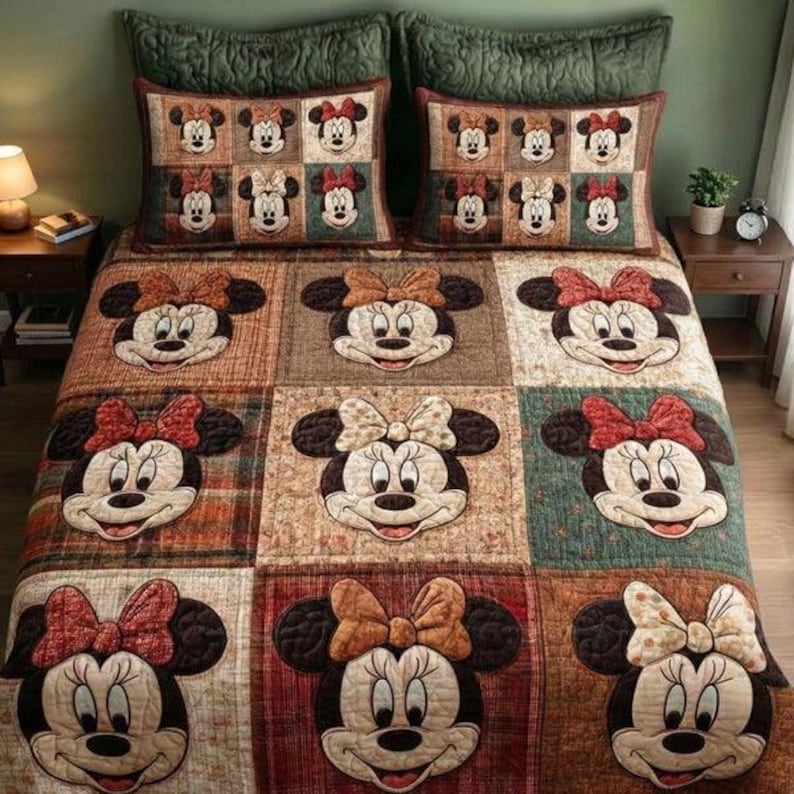May include: A patchwork quilt and two matching pillow shams featuring Minnie Mouse. The quilt showcases large Minnie Mouse faces with various bow colours. The pillow shams display a grid of smaller Minnie Mouse faces. The colour palette includes browns, reds, and greens.