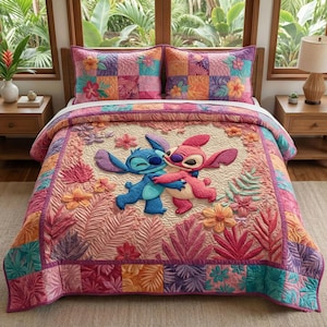 May include: A colorful quilt and two matching pillowcases featuring Stitch and Angel hugging. The bedding set has a patchwork design with floral and tropical leaf accents in shades of pink, orange, purple, and teal.