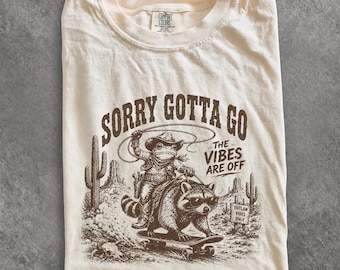 Sorry Gotta Go Frog Raccoon Skateboard Western Desert Tee