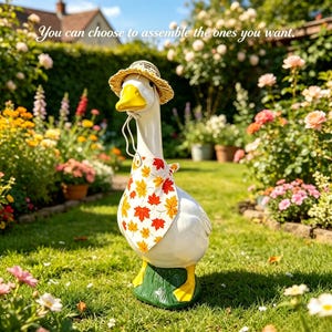 May include: A white goose figurine with a yellow beak and feet, wearing a straw hat and a white bandana featuring a colourful autumn leaf pattern. The figurine stands on a green base and includes the text: You can choose to assemble the ones you want.