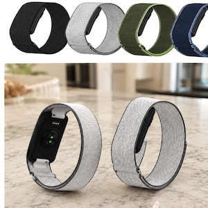 May include: A collection of elastic watch bands in black, light gray, olive green, and navy blue. The bands feature a woven fabric texture, a metal connector for attachment to a device, and a sliding adjustment mechanism for a secure fit.