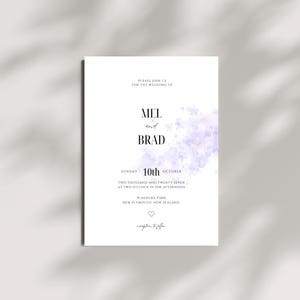 May include: A white wedding invitation card featuring black serif text that reads Mel and Brad, Sunday 10th October, two thousand and twenty-seven at two o'clock in the afternoon, Pukekura Park, New Plymouth, New Zealand, with a purple watercolor floral accent.