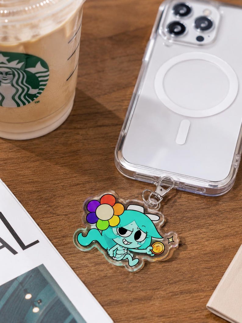 May include: A clear acrylic phone charm featuring a cartoon character with teal hair, a multi-colored flower, and a gold coin, attached to a transparent smartphone case. The charm has a glossy finish and a silver metal lobster clasp connector.