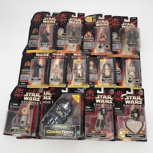 Puede incluir: Una colección de figuras de acción y accesorios de Star Wars Episodio I, aún en su embalaje original. Las figuras incluyen a Darth Maul, Obi-Wan Kenobi y otros personajes. El embalaje presenta el logotipo de Star Wars e imágenes de personajes.