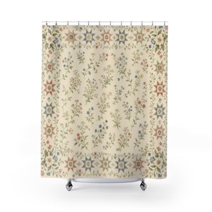 May include: A shower curtain with a cream-colored background featuring a central pattern of scattered small wildflowers in shades of red, blue, and green, framed by a border of alternating multi-colored star shapes and floral motifs.