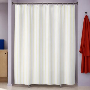 Pale yellow pinstripe shower curtain in a lilac modernist bathroom with vermilion robe and cobalt folio