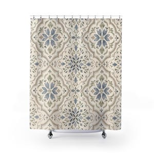 May include: A shower curtain featuring a repeating damask pattern in shades of muted blue, sage green, and beige. The design consists of interconnected quatrefoil shapes containing symmetrical floral motifs, suspended from a row of metal grommets.