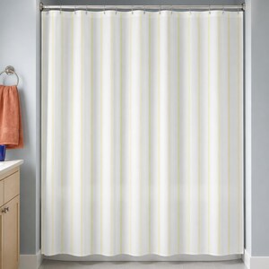 Pale yellow pinstripe shower curtain in a blue-gray bathroom with maple vanity and terracotta towel