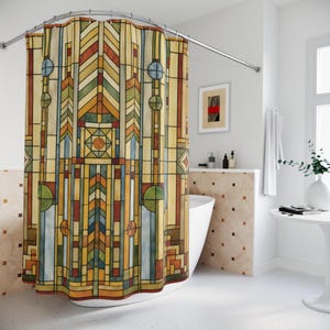 May include: A colorful shower curtain with a geometric stained-glass design. The curtain features vertical and horizontal lines in shades of yellow, brown, green, blue, and orange. The curtain hangs from a curved, silver-colored shower rod.