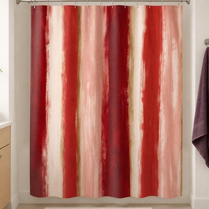 Painterly red stripe shower curtain in a warm white bathroom with birch vanity, plum towel and blush cup