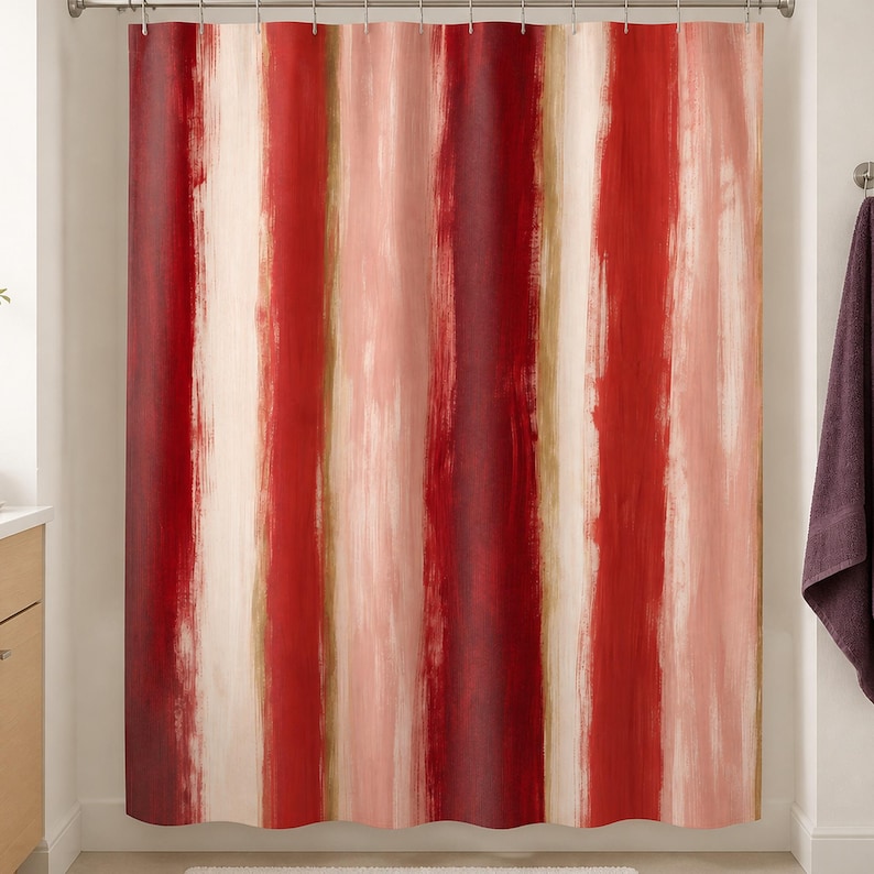 Painterly red stripe shower curtain in a warm white bathroom with birch vanity, plum towel and blush cup