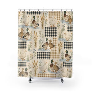 Op de afbeelding: Een douchegordijn met een herhalend patroon van eenden, korenaren en kleine wilde bloemen op een crèmekleurige achtergrond. Het ontwerp bevat rechthoekige vlakken met zwart-wit vichy-ruitjes en beige ruitjes, met kleine blauwe waterplassen.