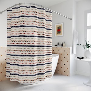 Puede incluir: Una cortina de ducha estampada con un fondo crema y diseños geométricos repetidos en azul marino, rojo y marrón. La cortina cuelga en un baño con una bañera blanca y una barra de ducha curva.