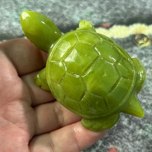 May include: A white ceramic mug with a black handle and the text "But First, Coffee" in a bold, black font. The mug is set against a blurred background, suggesting a cozy setting. The mug appears to be approximately 4 inches tall.