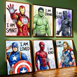 May include: Six framed wall art prints featuring superhero illustrations with watercolor backgrounds. Each print displays a character with a positive affirmation: Iron Man says I AM SMART, Hulk says I AM STRONG, Black Panther says I AM BRAVE, Captain America says I AM LOVED, Spider-Man says I AM KIND, and Thor says I AM HONEST.