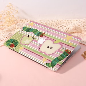 May include: Laptop case featuring a colorful design with a green caterpillar, apples, and stars on a pink and white striped background. The case is open, revealing the screen.