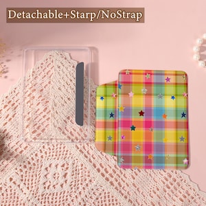 May include: A clear phone case with a gray magnetic strip next to a colorful phone cover. The phone cover has a plaid pattern in yellow, pink, green, and blue, decorated with star shapes. The text "Detachable+Starp/NoStrap" is at the top.