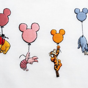 Puede incluir: Diseño bordado con personajes de Winnie the Pooh colgados de globos con forma de Mickey Mouse. Incluye a Pooh, Piglet, Tigger y Eeyore, cada uno con un globo en tonos rosa, naranja y azul. Sobre un fondo blanco.