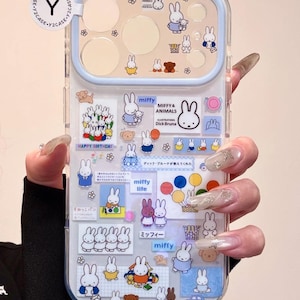 Op de afbeelding: Transparante telefoonhoes met illustraties van Miffy het konijn in verschillende poses en omgevingen. De hoes heeft een lichtblauwe rand en bevat tekst zoals "Happy Birthday" en "Miffy & Animals".
