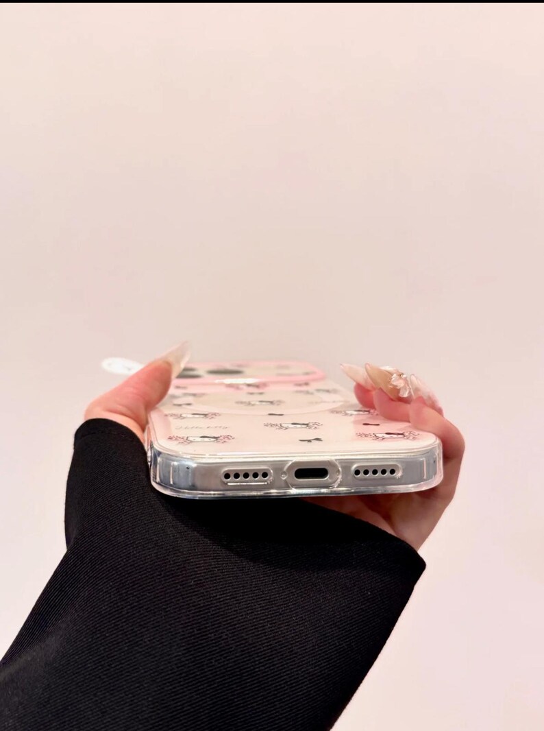 A bottom edge view shows the clear Hello Kitty phone case with the charging port and speaker cutouts visible.