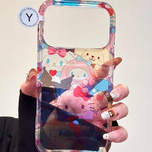 May include: Clear phone case featuring a colorful cartoon design with characters like My Melody and Hello Kitty. The case has a transparent border and a sticker that says "Y2CASE".