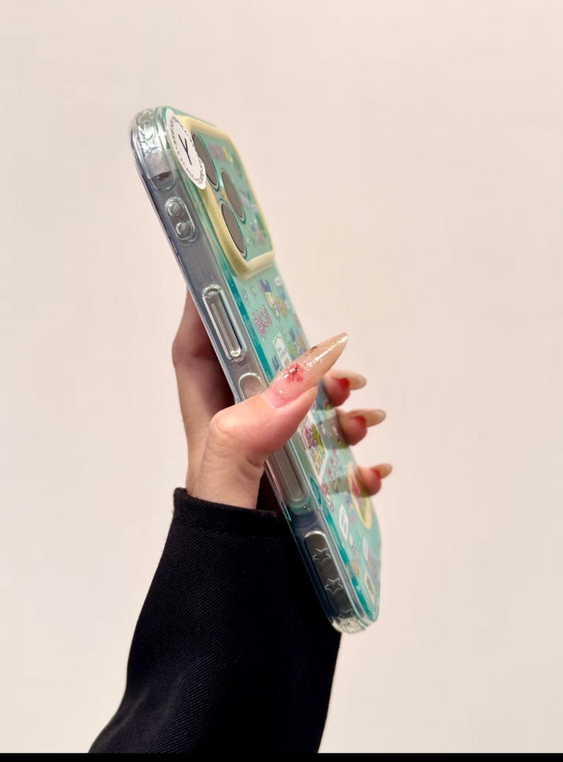 Puede incluir: Funda de tel&eacute;fono transparente con un dise&ntilde;o colorido con personajes de dibujos animados y elementos florales. La funda tiene un fondo azul claro y un &aacute;rea de c&aacute;mara amarilla. La funda est&aacute; hecha de un material transparente.