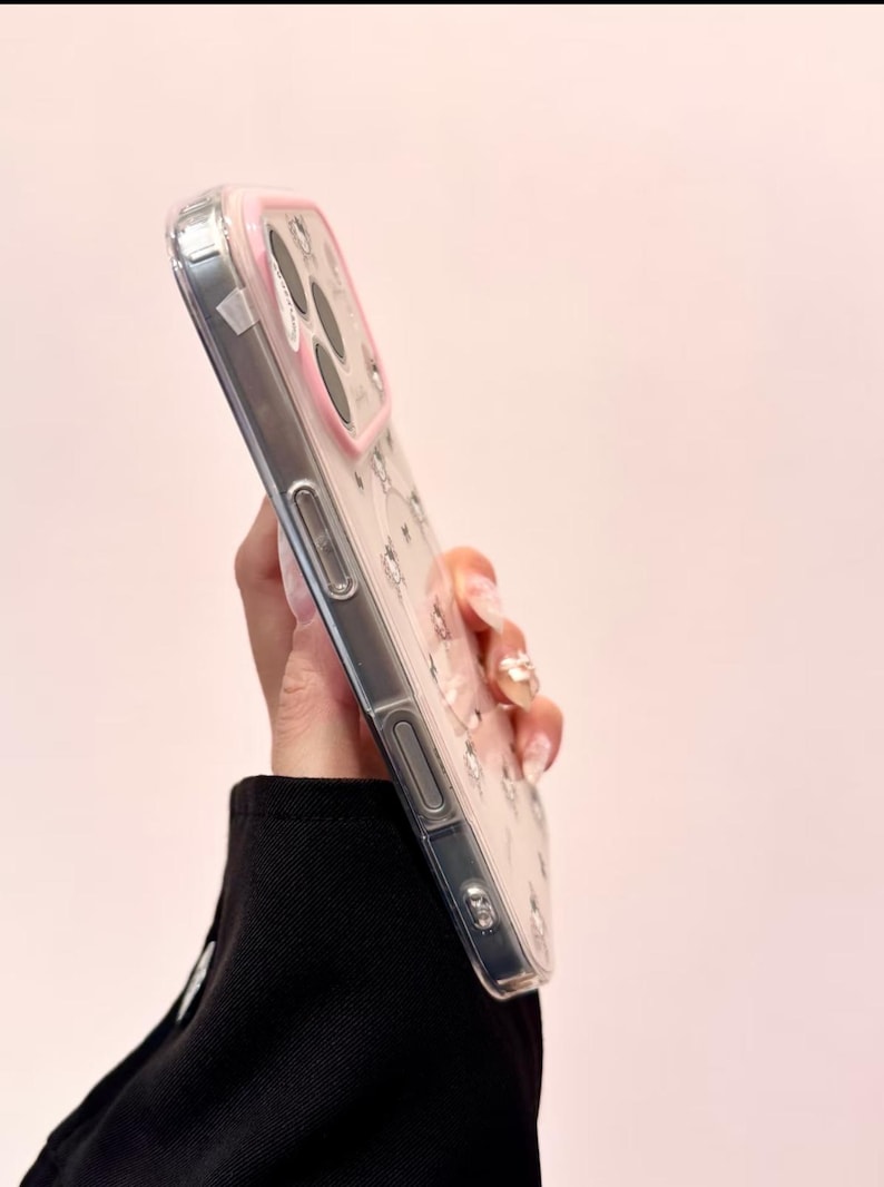 A side-profile view shows the clear Hello Kitty phone case edge and buttons from the side.