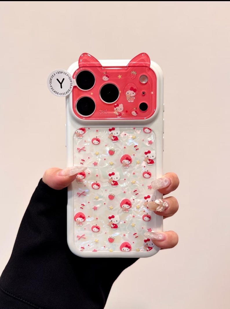 A close front view shows the Hello Kitty case with the red cat-ear camera cover and patterned pearly back.