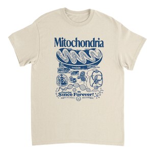 A tan short-sleeve t-shirt with a blue graphic of a mitochondria cell and related scientific diagrams and text.