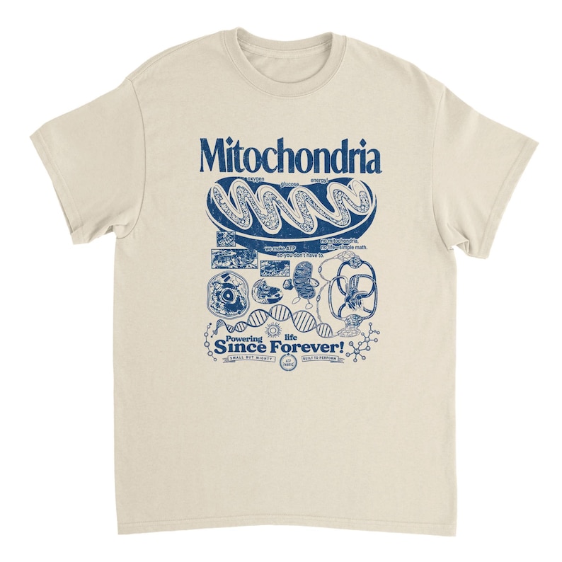 A tan short-sleeve t-shirt with a blue graphic of a mitochondria cell and related scientific diagrams and text.