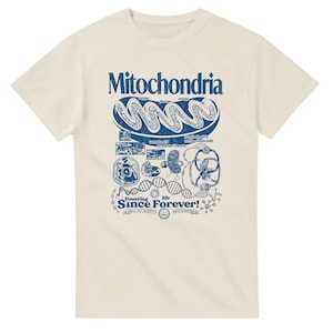A cream-colored short-sleeve t-shirt with a blue graphic of a mitochondria cell and related scientific diagrams and text.