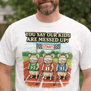 Könnte beinhalten: Weißes T-Shirt mit dem Text "YOU SAY OUR KIDS ARE MESSED UP!" über einer Grafik von drei verbundenen Mäusen am Start eines Rennens. Die Mäuse tragen nummerierte Trikots: grün 2, rot 1 und blau 3. Das Shirt hat einen Rundhalsausschnitt.