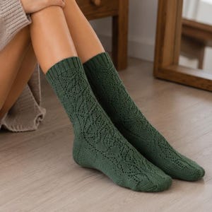 Puede incluir: Un par de calcetines a media pantorrilla de color verde bosque profundo, con un intrincado patrón de punto de cable texturizado en toda la pierna y el pie, con un puño acanalado en el borde superior para un ajuste seguro en la pierna.