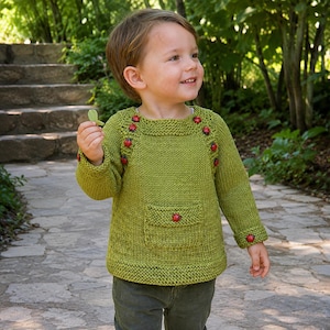 May include: A lime green long-sleeved knit jumper featuring a square neckline, a front pocket, and small red ladybug-shaped buttons arranged along the shoulders, cuffs, and the centre of the pocket. The jumper has a textured garter stitch trim.