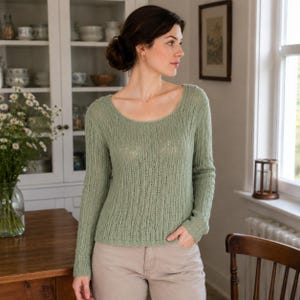 May include: A sage green long-sleeved sweater featuring a delicate vertical openwork knit pattern, a rounded scoop neckline, and a straight hemline. The garment is crafted with a lightweight, textured knit construction and has a fitted silhouette.