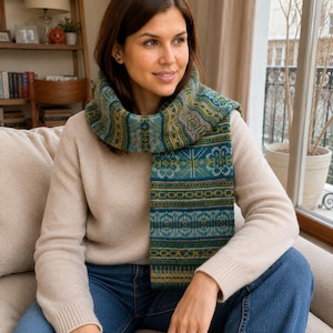 May include: A long knit scarf featuring a complex Fair Isle pattern in shades of teal, forest green, mustard yellow, and soft pink. The scarf displays repeating geometric motifs, horizontal stripes, and intricate floral-inspired designs throughout.