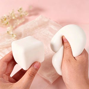 Squishy abstracto inspirado en una foca: cubo de marfil sin rostro y forma de tallo curvado, textura ultrasuave y rebote en 6 segundos para un juego consciente.