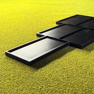 Peut inclure: Plusieurs plateaux rectangulaires noirs avec des surfaces textur&eacute;es sont dispos&eacute;s sur un fond textur&eacute; jaune-vert. Les plateaux sont faits d'un mat&eacute;riau sombre et ont un bord sur&eacute;lev&eacute;.