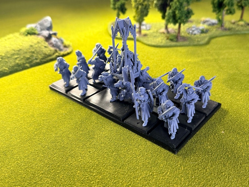 May include: Miniature figurines, possibly for a tabletop game, are arranged on a black base. The figures are a light blue-grey, representing soldiers with swords and other gear. The scene is set on a green, textured surface, resembling a battlefield.
