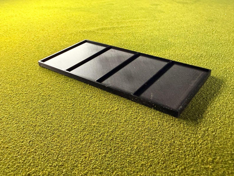 Peut inclure: Un plateau rectangulaire noir divis&eacute; en quatre compartiments &eacute;gaux. Le plateau est en mat&eacute;riau textur&eacute; et repose sur une surface textur&eacute;e jaune-vert. Les compartiments sont s&eacute;par&eacute;s par des s&eacute;parateurs sur&eacute;lev&eacute;s.
