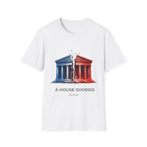 Peut inclure: T-shirt blanc avec un graphisme d'un bâtiment divisé en deux, bleu et rouge. Le texte indique "A HOUSE DIVIDED" et "ON POINT." Le motif est centré sur le t-shirt.