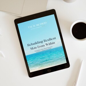 K&ouml;nnte beinhalten: Ein Tablet zeigt den Text "TALAY METHOD" und "Rebuilding Resilient Skin from Within" &uuml;ber einem blauen Ozeanbild. Ein Laptop, eine Tasse Kaffee, ein Stift und eine dekorative Vase befinden sich auf einer wei&szlig;en Oberfl&auml;che.