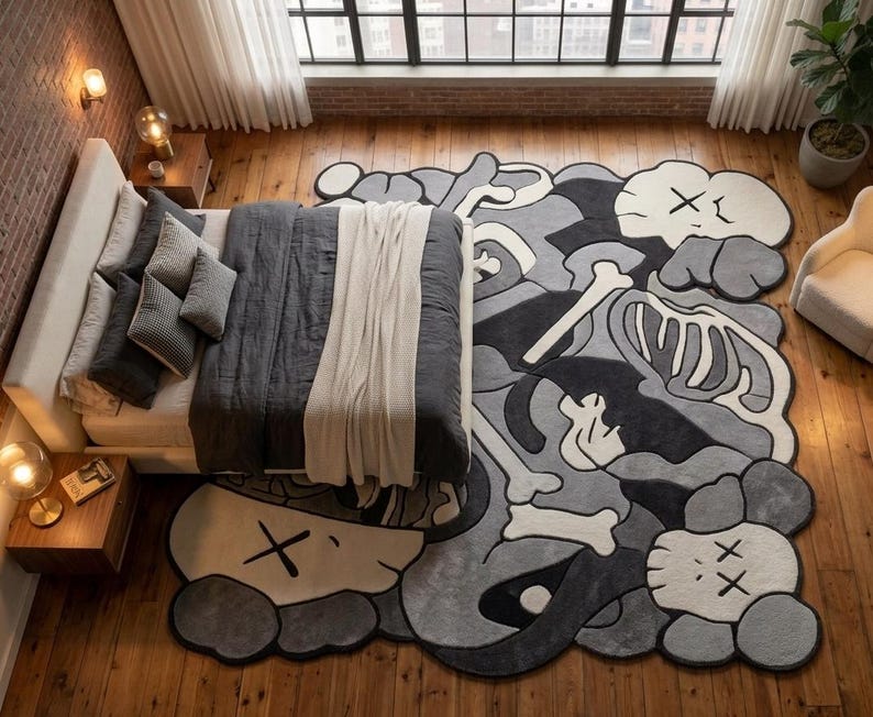 May include: A large, irregularly shaped area rug featuring a monochromatic graphic design in shades of black, grey, and white. The pattern includes stylised skull-like figures with X-shaped eyes and skeletal bone motifs across the surface.