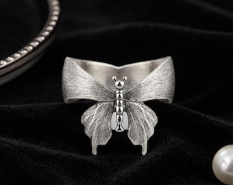 Anillo vintage de plata con forma de mariposa, acabado mate texturizado, estilo ciber medieval.